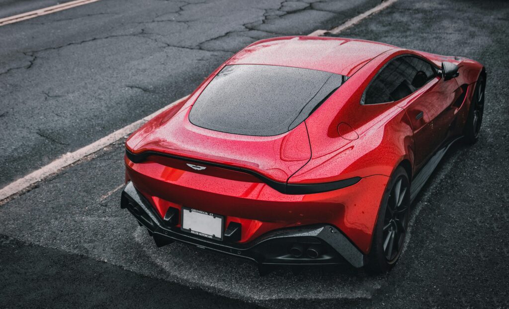 red aston martin on a suburban street
