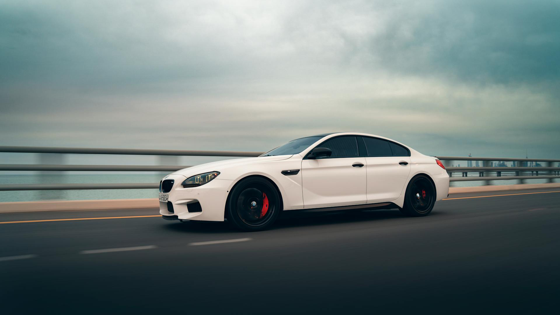 white bmw on a coastal road
